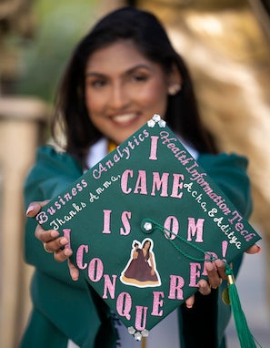 girl holding green decorated cap