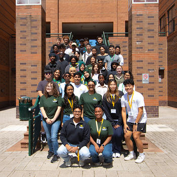 All Camp Costello participants and student mentors pose on the stairs in front of Enterprise Hall